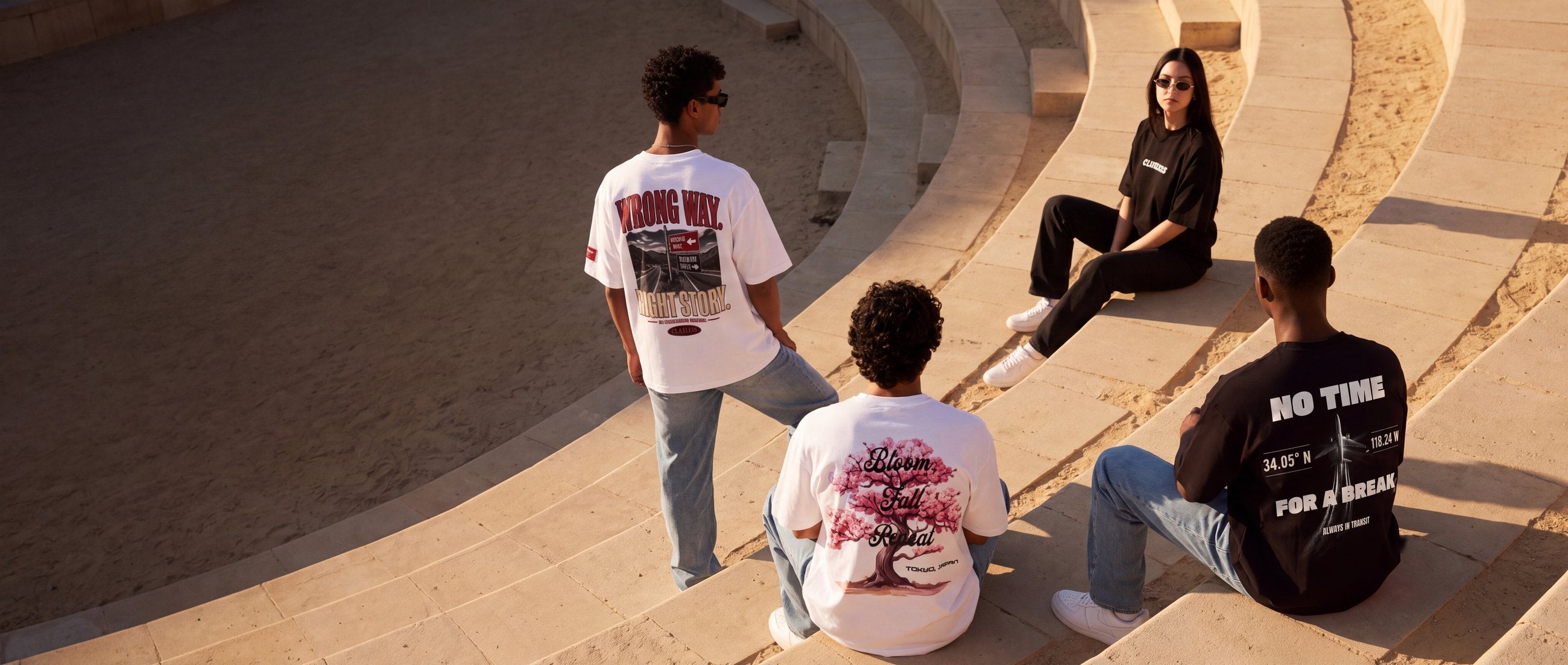 Four friends on golden sandstone steps, the Sakura, In Transit and Wrong Way back prints nearest the camera