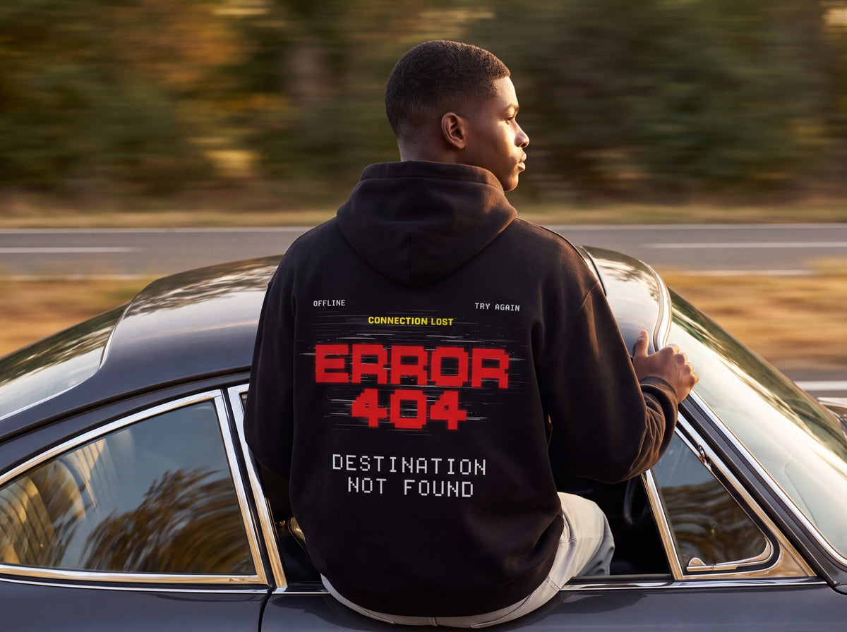 Model from behind in the black Error 404 oversized hoodie, concrete underpass at night